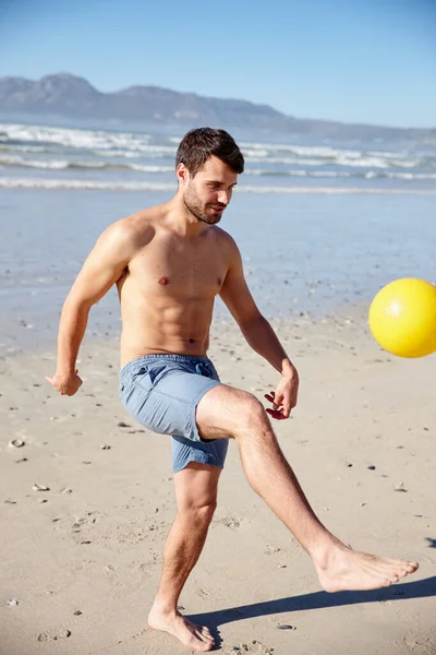 夏天是玩耍的时间 一个在海滩上踢球的年轻人 — 图库照片