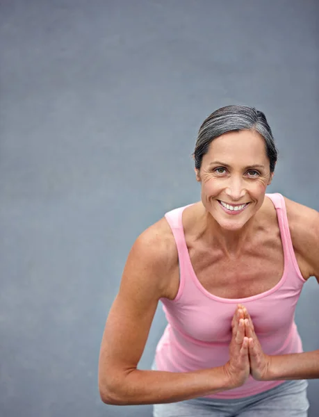 stock image Feeling energized through yoga. High angle view of an attractive mature woman doing yoga outdoors