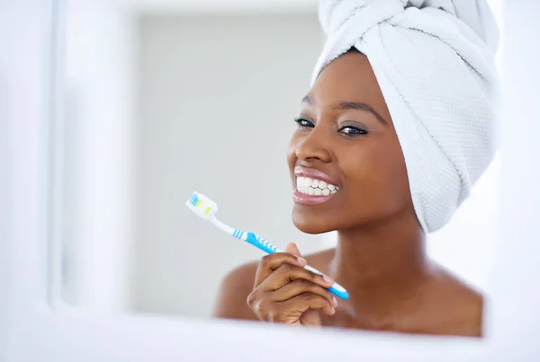 Tending to her pearly whites. an attractive young woman brushing her teeth in the morning