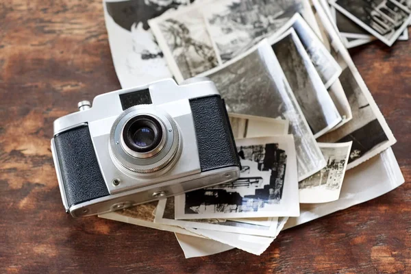 Memories to be treasured. An old-fashioned camera lying on top of a pile of black and white photographs
