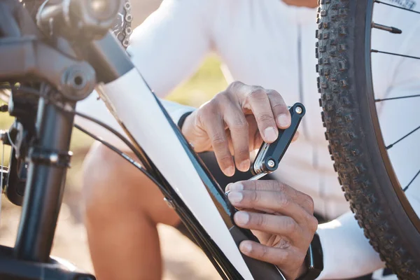 Repair, tools and hands of man with mountain bike for fitness, training and exercise in nature. Cycling, sports and adventure with cyclist fixing bicycle on trail for gears, maintenance or inspection.