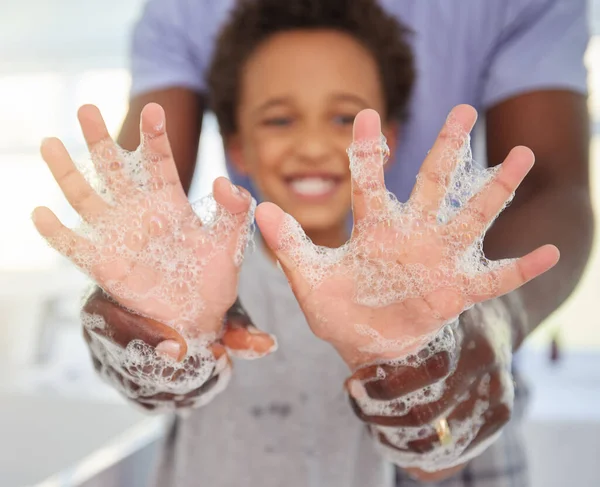Black family, washing hands and soap foam with a father and child in a bathroom with a smile. Blurred background, papa helping and hygiene support of a kid with dad together with happiness and care.