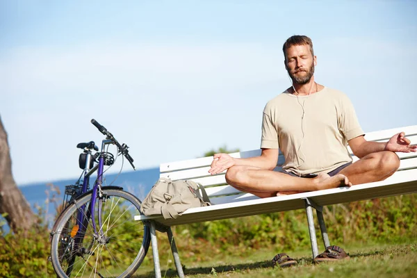 Total relaxation...a mature man doing a relaxation exercise while sitting on a park bench