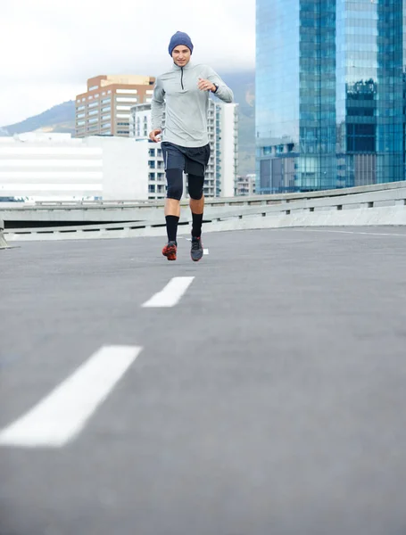 街の通りをリッピング 空の街をジョギングする若い男の低角度ショット — ストック写真