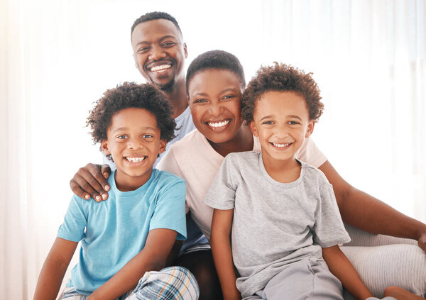 Happy, relax and portrait of black family in bedroom for morning routine, wake up and bonding. Affectionate, happiness and smile with parents and children at home for weekend, support and positive.