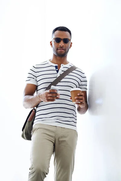 クールでカジュアルなビジネス 彼の携帯電話とコーヒーを保持しながら 階段を歩くスタイリッシュな 気軽に疲れ若いビジネスマン — ストック写真
