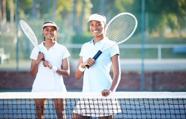 Tennis, team and portrait with women on outdoor court, sports and fitness with collaboration and ready for game. Exercise, workout and female smile, athlete and workout with partnership and racket.
