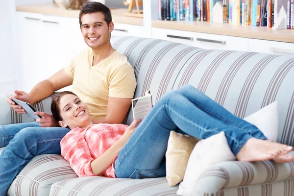 どちらも熱心な読者である ソファの上で家でリラックスしている若いカップル — ストック写真