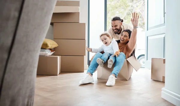 Happy family play in cardboard box for new house, moving and real estate celebration, investment and excited game. Mom, dad and kid or child play in boxes while moving into property home together.
