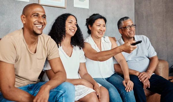 stock image Movie watching, living room and family together with a smile in a home. Black woman, man and senior people with happiness and tv remote in a house with elderly parents feeling happy from bonding.