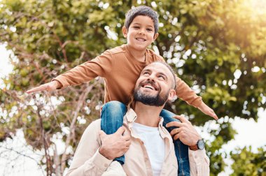 Baba, çocuk ve aile bağları, yaz tatili ya da dışarıda tatil için doğada mutlu yolculuklar. Mutlu baba oğlunu sırtında taşırken gülümseyerek parkta tatilin tadını çıkarıyor..