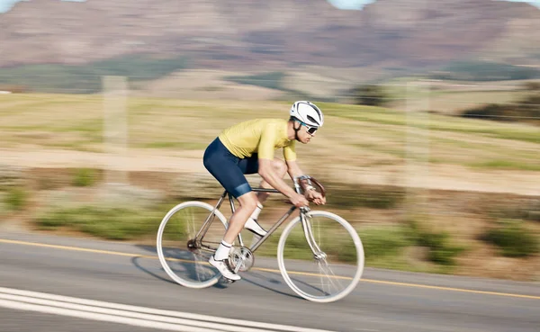 Cycling, fitness and man with bicycle on road, speed and action, motion blur of cyclist outdoor and helmet for safety. Mockup space, athlete and training for race, exercise in countryside with bike.
