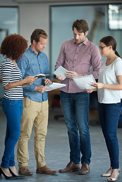 stock image Hashing out ideas together. a group of coworkers standing in an office talking