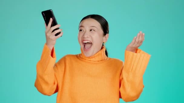 Stüdyonun Arka Planında Izole Edilmiş Bir Telefon Üzerinden Asyalı Kazanma — Stok video