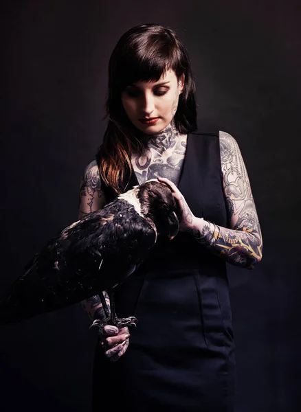 어둠을 길들이는 스튜디오에서는 새를들고 문신을 여자의 사진을 찍었다 — 스톡 사진