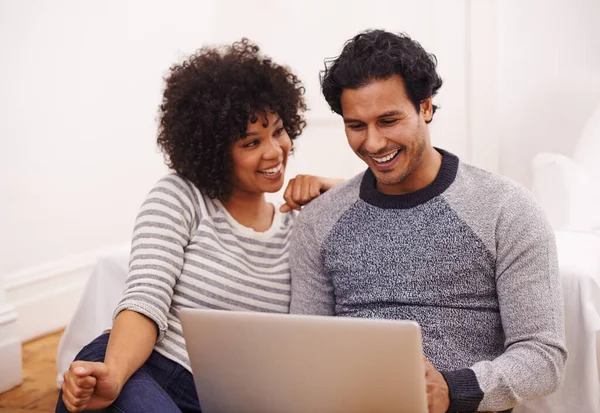 在技术上一起一对快乐的年轻夫妇在客厅里一起使用笔记本电脑 — 图库照片