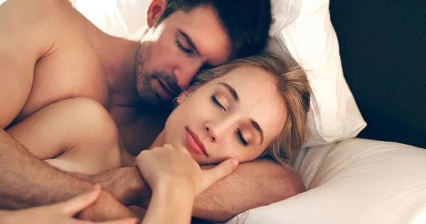 在他的怀里找到安慰一对深情的年轻夫妇睡在床上的高角镜头 — 图库照片