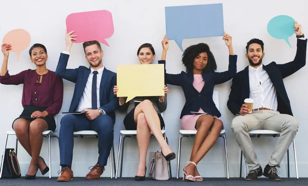 Dont be afraid to express yourself. Full length portrait of a diverse group of businesspeople sitting and holding blank cards while in the office