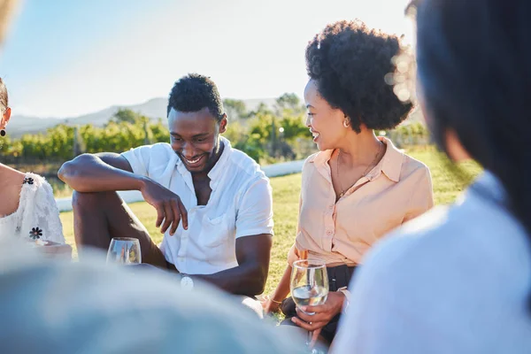 Happy, wine or couple of friends at a picnic relaxing or bonding on a summer holiday vacation in nature. Smile, black woman and funny black man enjoying quality time and drinking alcohol in a park.