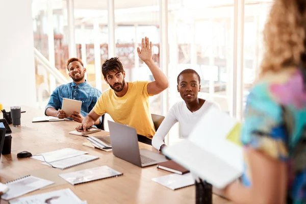 stock image If I may. Cropped shot of a handsome young male designer raising his hand while sitting in the boardroom during a meeting