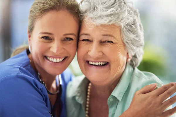 让她的病人精神振作一个微笑的护士和她的老年病人在医院的画像 — 图库照片