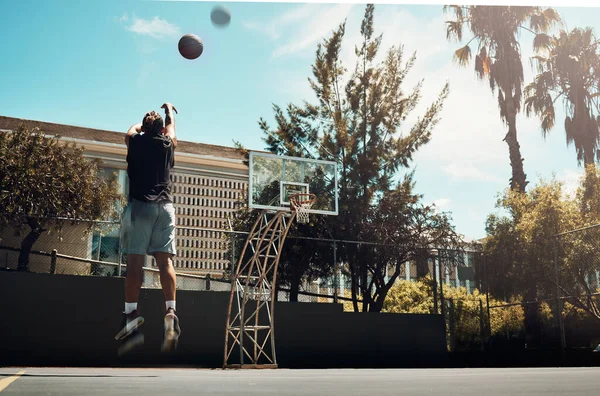 バスケットボール アウトドア 夏の太陽のマイアミのバスケットボールコートで一人でボールを撃つ男 フィットネス トレーニング バスケットボール選手が週末のスポーツゲームの練習でコートで得点にジャンプ — ストック写真
