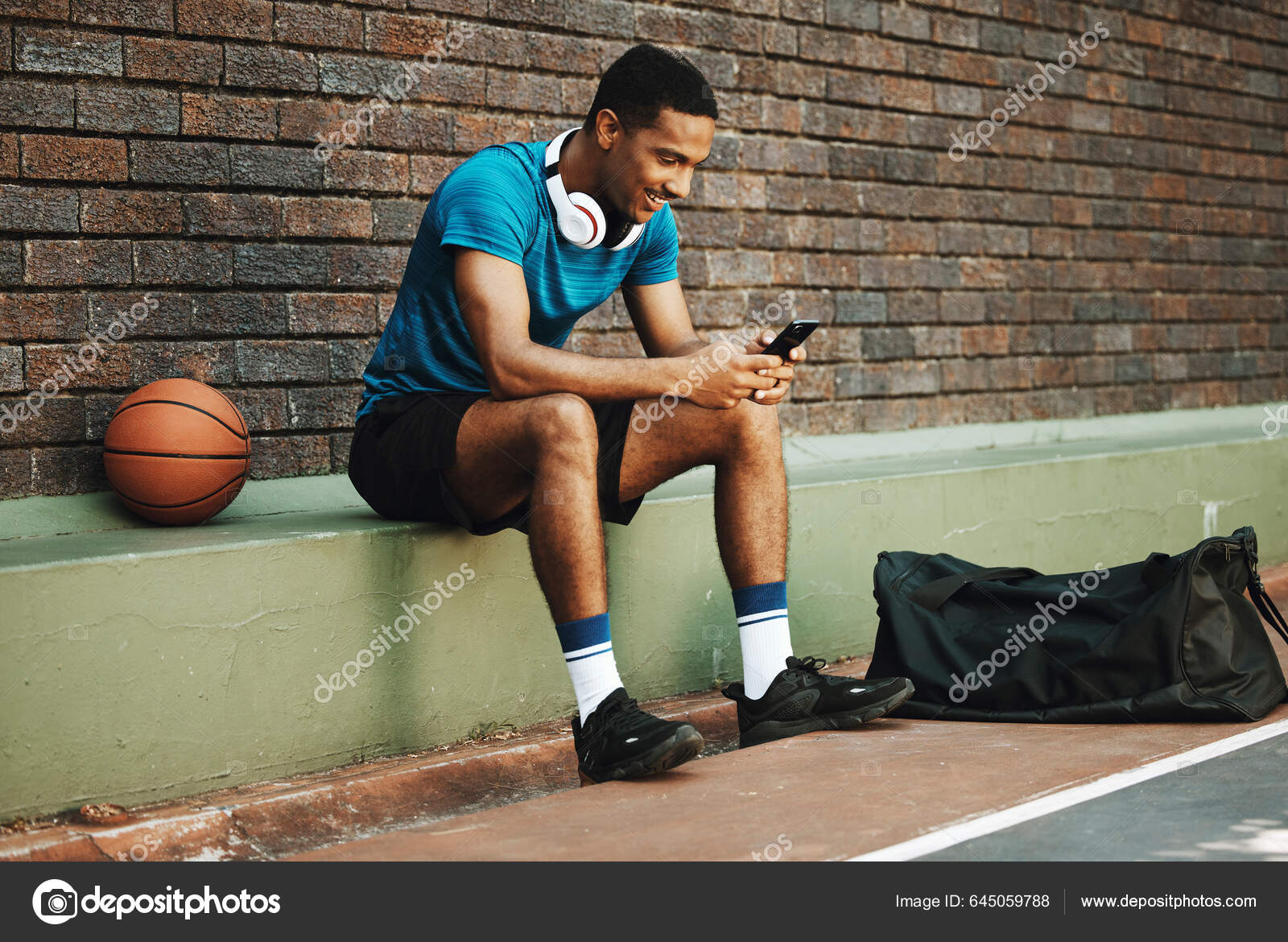 Esportivo com bola para jogar basquete, ouvindo música em fones de