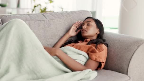 頭痛のある女性 ソファでリラックスし 病気や痛み 片頭痛や健康上の問題を自宅で休んで インドの女性 頭の寒さとスマートフォン 疲労感と身体的病気のストレス — ストック動画