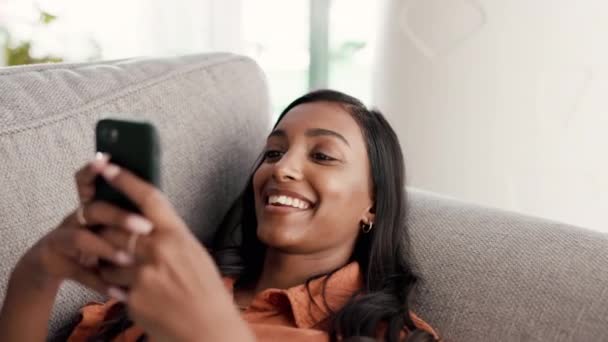 电话和微笑在客厅沙发上聊天 在家进行交流 发短信或社交媒体 快乐的女性在沙发上放松 微笑着 或在智能手机上打字 以建立联系 浏览或聊天 — 图库视频影像