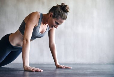 Zor, ama buna değer. Spor salonunda şınav çeken bir kadın.