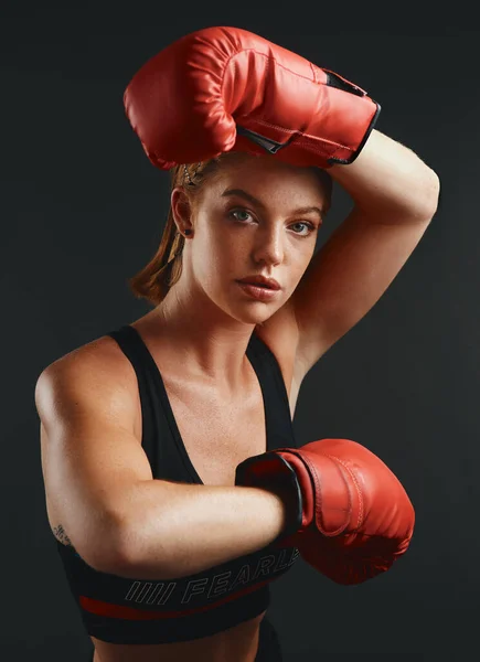 あなたは決意で何でもすることができます 黒を背景にボクシンググローブを身に着けているスポーティな若い女性のスタジオの肖像画 — ストック写真