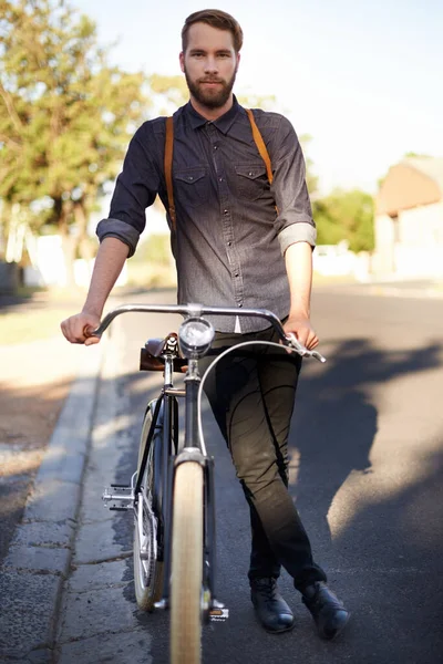 On the nerd mover. A young man standing with his bicycle outdoors