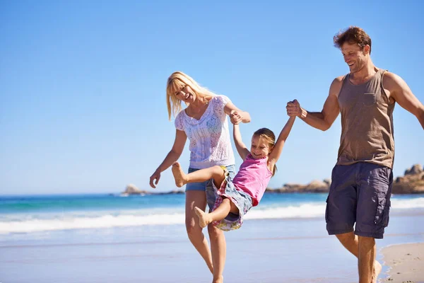 ビーチで遊ぶ ビーチで散歩をしている幸せな若い家族が — ストック写真