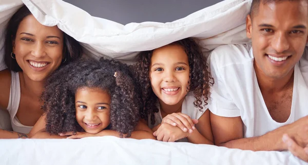 ベッドの上で幸せな黒い家族の絆の肖像画 一緒にベッドルームでリラックスして笑顔 幸福両親は子供たちと自由な時間を楽しんでいます — ストック写真