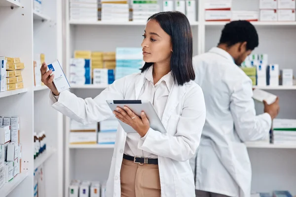 Pharmacy stock tablet, Indian pharmacist and nurse checklist of medicine and pills. Woman, digital work and pharmaceutical products in a retail shop or clinic with healthcare and wellness employee.
