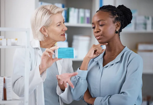 Suggestion, help and black woman with medicine from a pharmacist, dosage information and recommendation. Medical, sick and doctor reading label on a box of pills with an African patient for medicare.