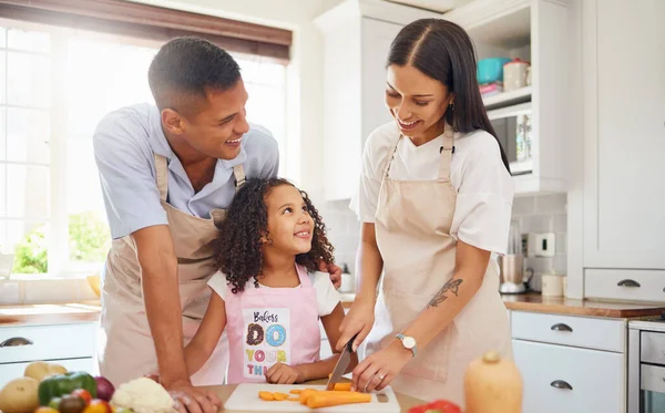 Happy family, love and cooking healthy food in the kitchen in preparation for a vegan diet for dinner or lunch together. Development, father and mother teaching child a vegetable salad recipe at home.