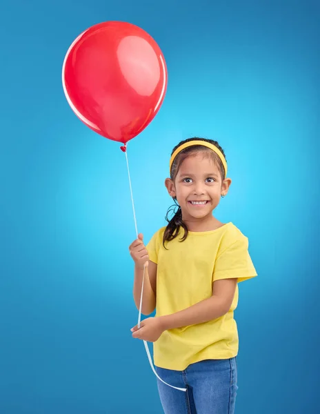 誕生日パーティーの準備ができて笑顔で興奮した子供の幸せな女の子 スタジオ 赤い風船 独立した青の背景を持つ空中で風船を保持するお祝い 幸福と若い子供 — ストック写真