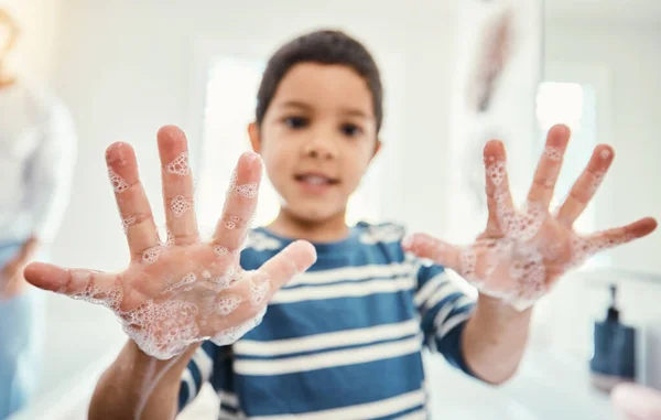 Cleaning, hands with soap and boy in bathroom for hygiene, wellness and healthcare at home. Healthy family, skincare and portrait of child with open palms washing with water, soap and disinfection.