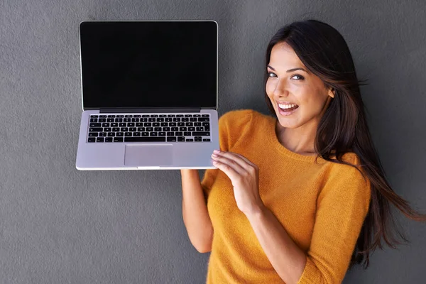看看这个很酷的网站 一个有魅力的年轻女子拿起一台带有空白屏幕的笔记本电脑的画像 — 图库照片