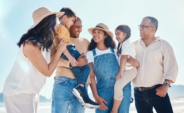 Kids, beach and summer with a black family together outdoor on the sand by the ocean or sea for holiday. Children, love or nature with siblings, parents and grandparents bonding outside on the coast.
