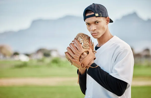 Portrait pitcher, baseball player or man training for a sports game on outdoor field stadium. Fitness, motivation or focused athlete pitching or throwing a ball with a glove in workout or exercise.