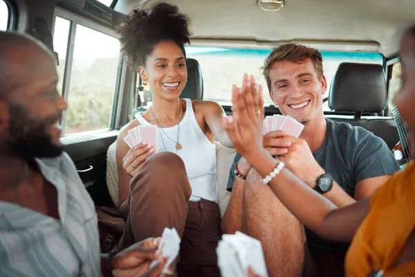 Card game, car and friends high five on a road trip enjoy holidays, vacation or fun weekend together. Winner, happy and excited girls celebrate playing, winning or victory with a smile in a caravan.