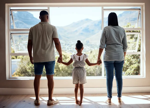 Family, child or girl by window in new house, home or apartment with mortgage loan, finance security or future investment property. Mother, father and kid as real estate homeowner with mountains view.