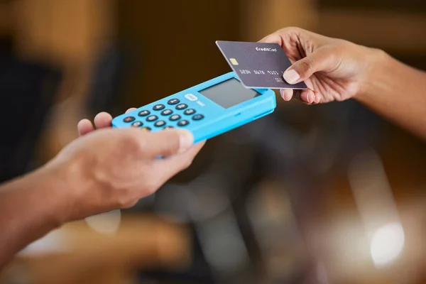 Hands, credit card and machine for ecommerce, payment or wireless transaction and purchase at retail store. Hand of customer paying, buying or tap to pay on electronic POS device for easy banking.