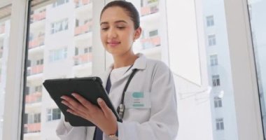 Tablet, hastane ve mutlu kadın doktor sağlık başvurusu, tele sağlık güncellemesi ya da klinik veri araştırması. Dijital teknolojide çalışan genç tıbbi uzman ya da kadın hemşire staj ile sonuçlanır.