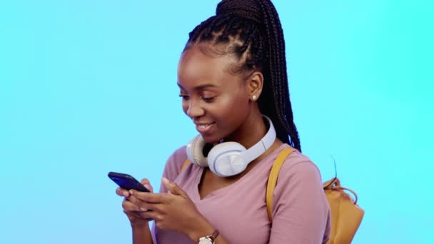 ソーシャルメディア モバイルアプリ インターネット上のスタジオネットワーク内の電話 幸せと黒の女性 携帯電話に青い背景でテキストメッセージを入力する幸福 アフリカの女性モデル — ストック動画