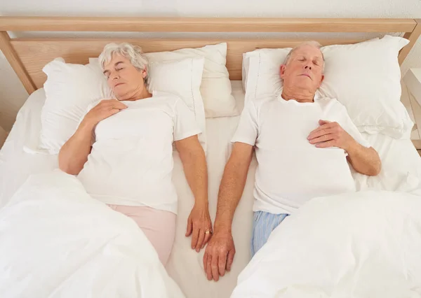 共生の生涯 ベッドの中で眠っている高齢者のカップルの高角度ショット — ストック写真