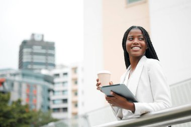 Siyahi bir kadın, kahve molası ve ofis dışında tabletle çalışan bir şirket çalışanı. Şehir ve kariyer pazarlamacısı olarak çalışıyor. Dijital teknoloji, Afro-Amerikan profesyonel ve bir iş kadını..