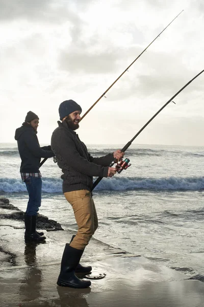 钓大鱼 两个年轻人一大早在海里钓鱼 — 图库照片